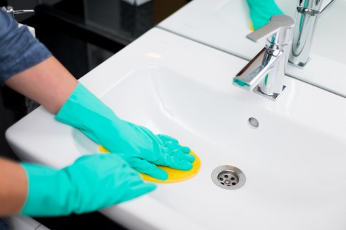 Cleaner wearing PPE while working on a carpet in a home